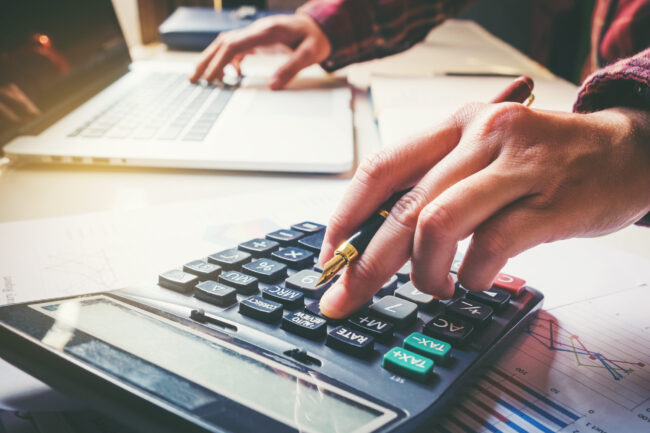 Businessman’s,Hands,With,Calculator,At,The,Office,And,Financial,Data