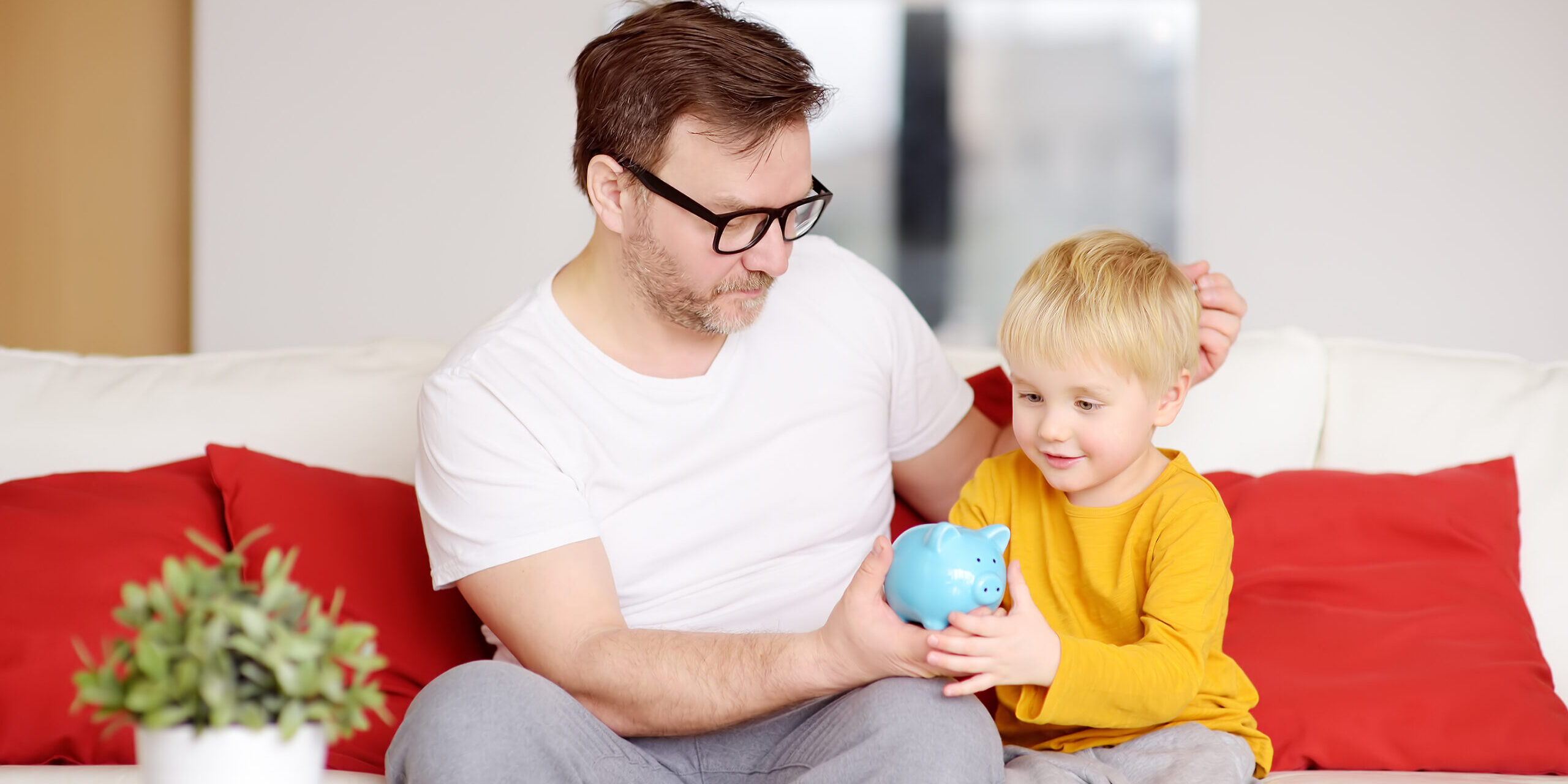 Father,And,Son,Putting,Coin,Into,Piggy,Bank.,Education,Of