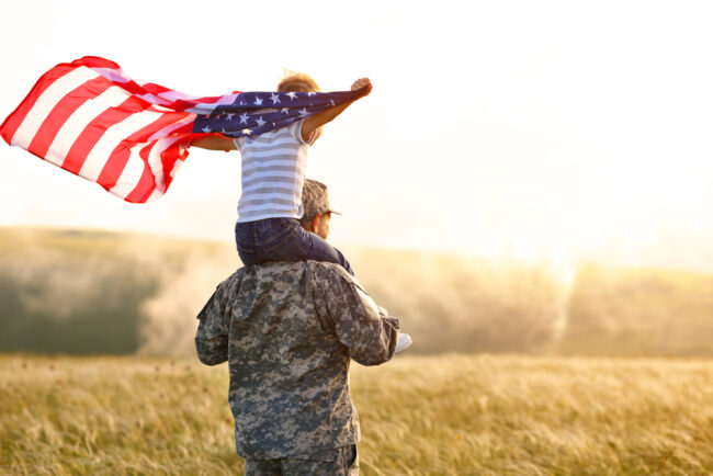 Rear,View,Of,Military,Man,Father,Carrying,Happy,Little,Son