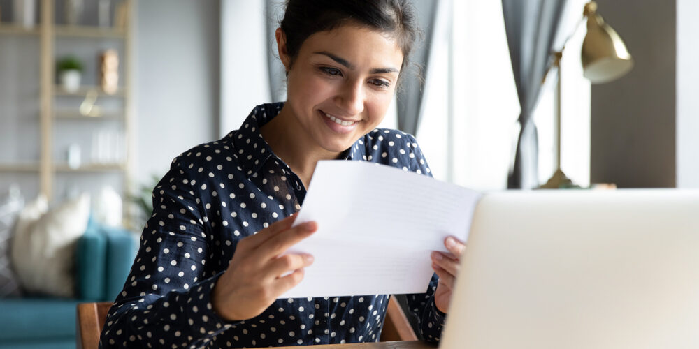 Smiling,Young,Indian,Woman,Holding,Paper,Bill,Letter,Doing,Paperwork