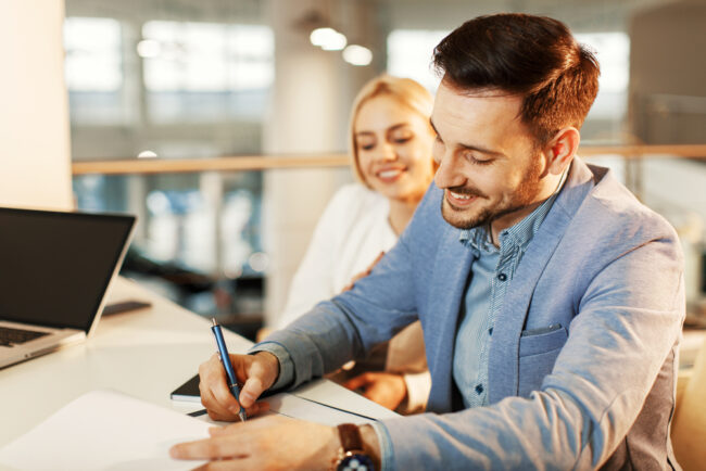 Young,Business,Couple,Signing,A,Contract