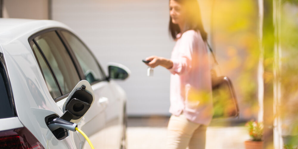 Close,Up,Of,A,Electric,Car,Charger,With,Female,Silhouette