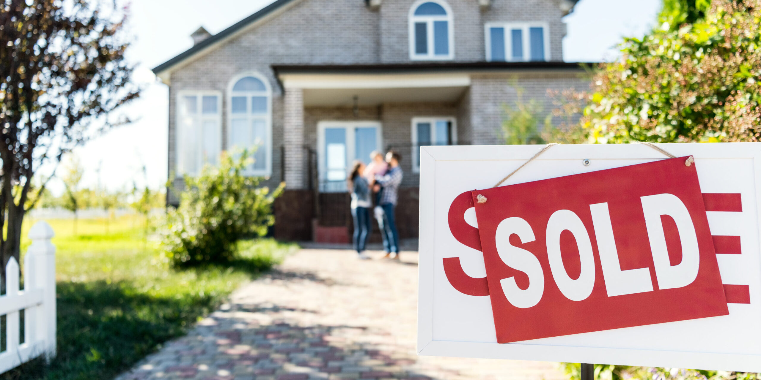 Sold,House,With,Blurred,Family,On,Background