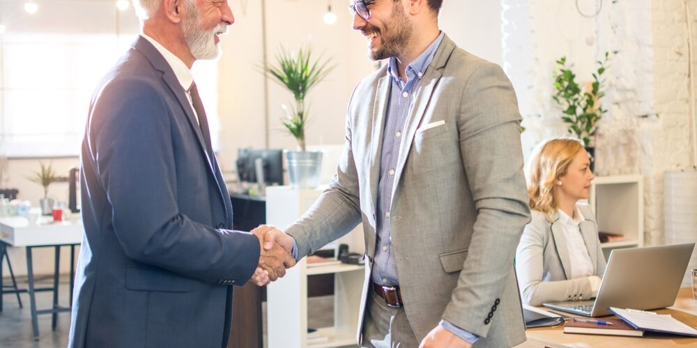 Senior,Executive,Shaking,Hands,With,Young,Employee,At,Office.