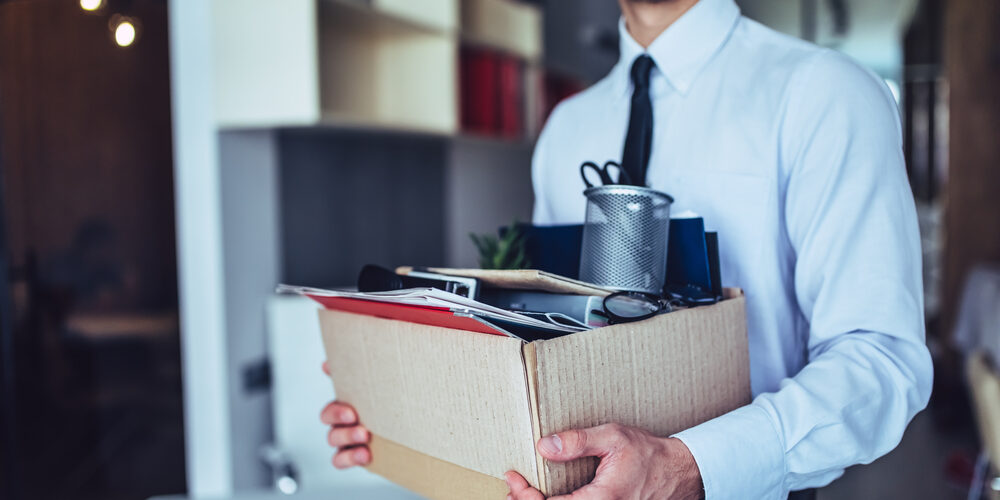 Young,Handsome,Businessman,In,Light,Modern,Office,With,Carton,Box.