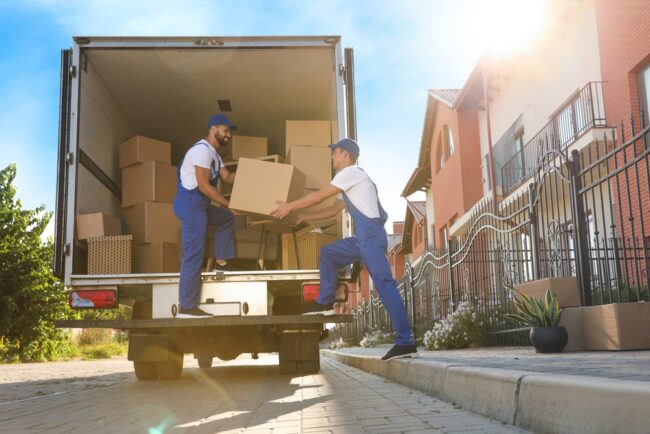 Workers,Unloading,Boxes,From,Van,Outdoors.,Moving,Service
